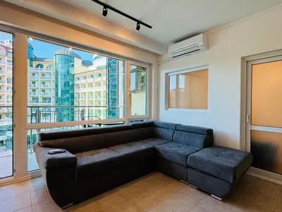 a living room with a couch and a large window at MIRAMAR A 501 Private Apartment Sunny Beach in Sunny Beach