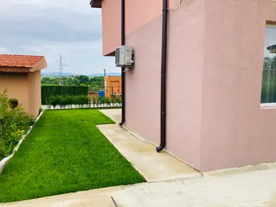a yard with green grass next to a pink building at Saint Anastasia lozenets in Lozenets