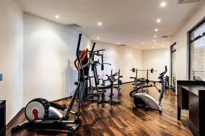 a gym with several tread machines in a room at The Cliff Hotel and Holiday Apartments by Flat Mаnаger in Obzor