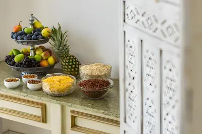 a counter with bowls of fruit and other food on it at The Cliff Hotel and Holiday Apartments by Flat Mаnаger in Obzor