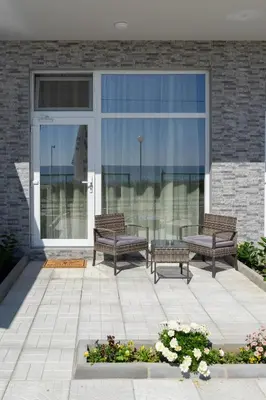 two benches sitting in front of a building with windows at Paradise View Rooms in Shkorpilovtsi