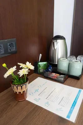 a table with a menu and a flower pot on it at Paradise View Rooms in Shkorpilovtsi