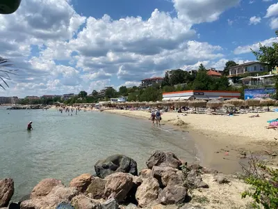 people on a beach with rocks in the water at LAZUR 1 Apartment 7- 5 Sveti Vlas in Sveti Vlas