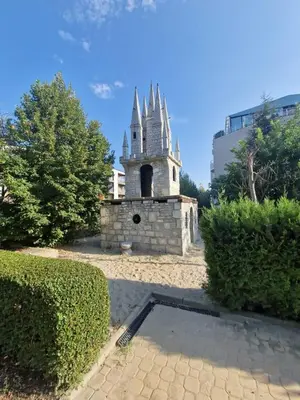 a stone building with a tower in a park at Апартамент МеГи in Burgas City