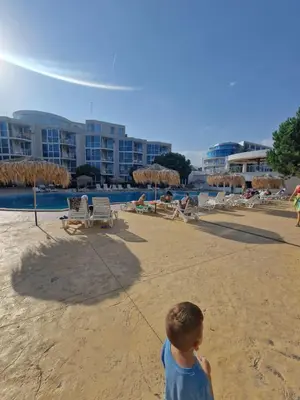 a young boy flying a kite on the beach at Апартамент МеГи in Burgas City