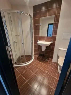 a bathroom with a shower and a sink and a toilet at Апартамент МеГи in Burgas City