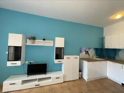 a kitchen with white cabinets and a blue wall at Menada Kalia Apartments in Sunny Beach
