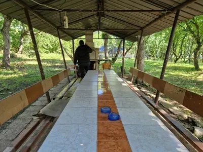 a man walking down a walkway with blue bowls on it at Хижа 