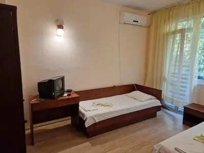 a small bedroom with a bed and a television at Хижа 
