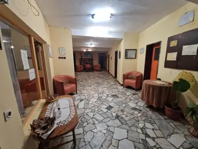 a hallway of a hospital with chairs and a table at Хижа 