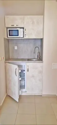 a small kitchen with a sink and a microwave at Амон Ра in Primorsko