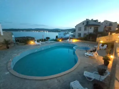 a swimming pool with chairs and a view of the water at 2 Bed Suite, Exclusive Sea Views in Sozopol