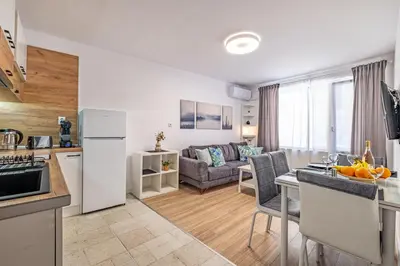 a kitchen and living room with a couch and a table at Cozy Central Apartment Varna & Parking - subject to availability in Varna City