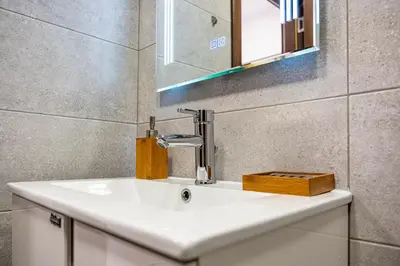 a bathroom with a white sink and a mirror at Cozy Central Apartment Varna & Parking - subject to availability in Varna City