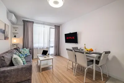 a living room with a couch and a table with a laptop at Cozy Central Apartment Varna & Parking - subject to availability in Varna City