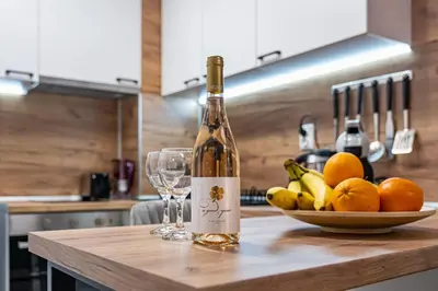 a bottle of wine sitting on a counter with a bowl of fruit at Cozy Central Apartment Varna & Parking - subject to availability in Varna City