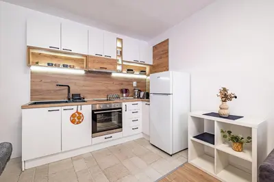 a kitchen with white cabinets and a white refrigerator at Cozy Central Apartment Varna & Parking - subject to availability in Varna City