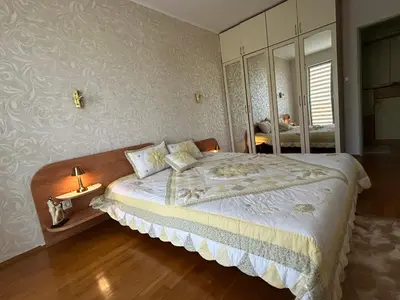 a bedroom with a large bed and a mirror at Nesebar City Apartment in Nesebar
