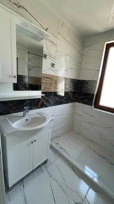 a white bathroom with a sink and a mirror at Zigrabay lovely appartments in Primorsko