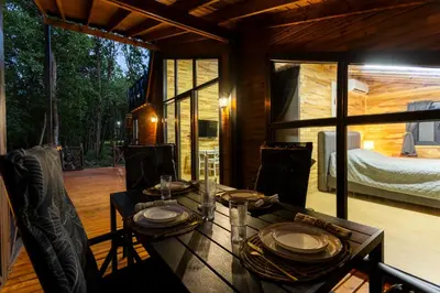 a dining room with a table and chairs on a patio at Lion's Forest in Atiya