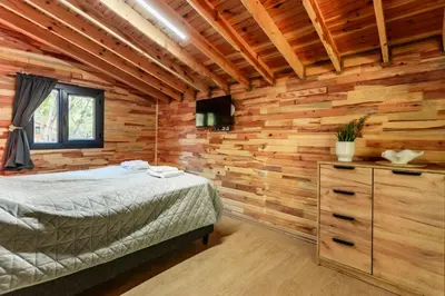 a bedroom with a bed in a log cabin at Lion's Forest in Atiya