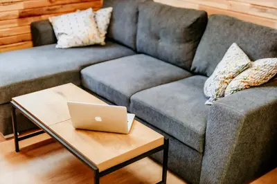 a living room with a couch and a laptop on a coffee table at Lion's Forest in Atiya