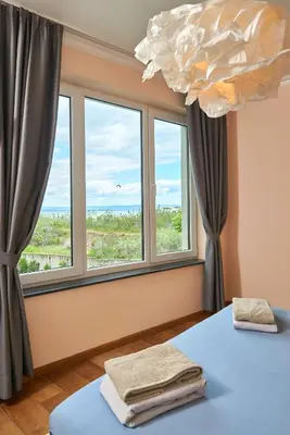 a room with a bed and a large window at Sea view Apartment Pomorie in Pomorie