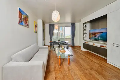 a living room with a white couch and a table at Sea view Apartment Pomorie in Pomorie