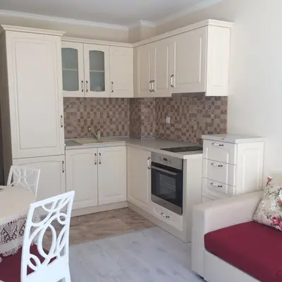 a white kitchen with white cabinets and a white chair at Apartment Alex Sveti Vlas in Sveti Vlas