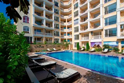 a hotel with a swimming pool in front of a building at Apartment Alex Sveti Vlas in Sveti Vlas