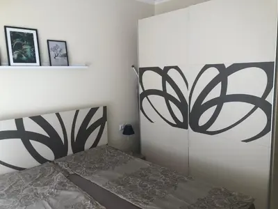 a bedroom with a bed with a black and white headboard at Apartment Alex Sveti Vlas in Sveti Vlas