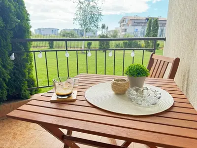 a wooden table with a plate of food on a balcony at MaYana Beach Appartament in Burgas City