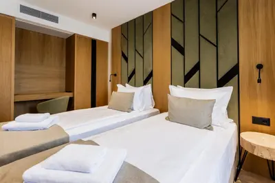 a hotel room with two beds and a table at Natura All Seasons Boutique Hotel in Burgas City