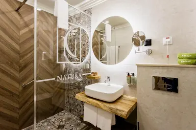 a bathroom with a sink and a mirror at Natura All Seasons Boutique Hotel in Burgas City