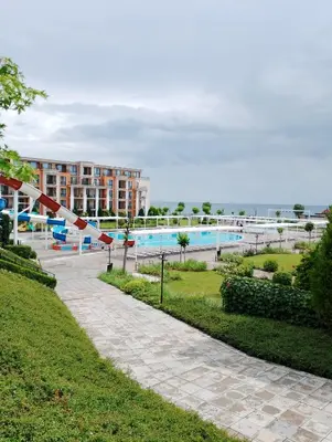 a swimming pool with a building in the background at Private Apartment in PREMIER FORT Beach Aparthotel in Sveti Vlas