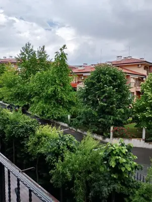 a view of a street with trees and a building at Private Apartment in PREMIER FORT Beach Aparthotel in Sveti Vlas