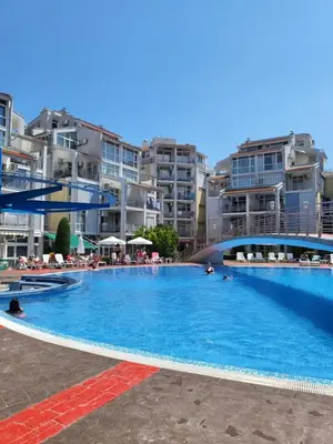 a large swimming pool with buildings in the background at Апартамент Бриджит Слънчев бряг in Sunny Beach