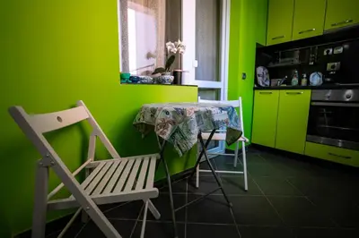 a kitchen with green walls and a table and chairs at Seaside Apartament in Burgas City