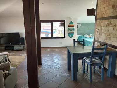 a living room with a table and a tv at Горе на вилата in Shkorpilovtsi