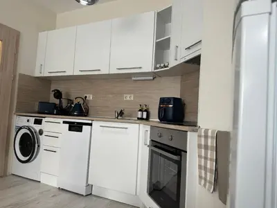 a kitchen with white cabinets and a washer and dryer at Elizi summer house in Varna South Bay Beach in Varna City