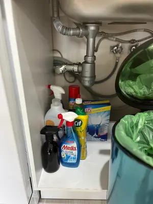 a bathroom shelf with cleaning products and a sink at Elizi summer house in Varna South Bay Beach in Varna City