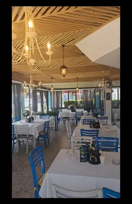 a dining room with white tables and blue chairs at Семеен Хотел ''Кораб Ренеса'' in Ravda