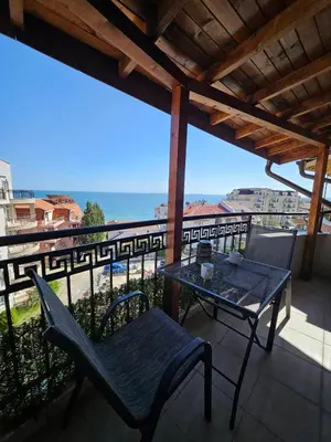 a table and chairs on a balcony with a view of the ocean at LaRenta Стилни апартаменти с 2 спални и гледка море в Свети Влас in Sveti Vlas