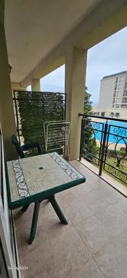 a balcony with a table and a chair on a patio at Частно студио в комплекс Поморие Ризорт in Pomorie
