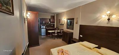 a small room with a bed and a kitchen at Частно студио в комплекс Поморие Ризорт in Pomorie