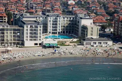 a beach with umbrellas and people on the beach at Частно студио в комплекс Поморие Ризорт in Pomorie