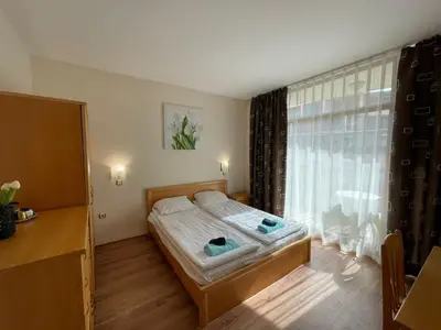 a bedroom with a bed and a large window at Grenada - Apartments by the beach in Sunny Beach