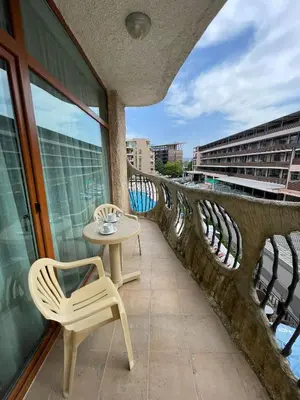 a table and chair on a balcony with a view at Grenada - Apartments by the beach in Sunny Beach