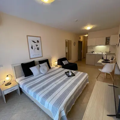a bedroom with a large bed and a kitchen at Royal Sun - Premium Apartments in Sunny Beach