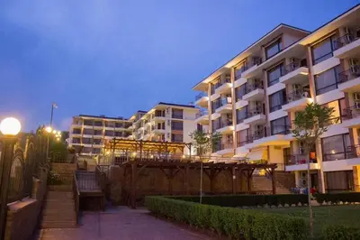 a apartment building at night with a bench in front at Macon Residence - Premium Apartments in Sveti Vlas